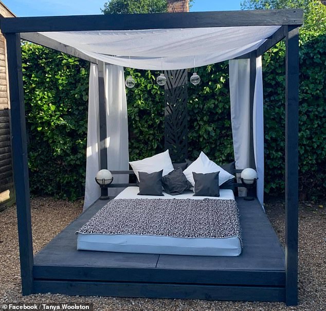 De Britse Tanya Woolston gebruikte oude houten pallets, £ 70 aan hout en materiaal dat ze al in huis had liggen om de privéoase in de achtertuin van haar moeder te creëren. Met zwarte beits heeft ze het bed een stoere look gegeven.