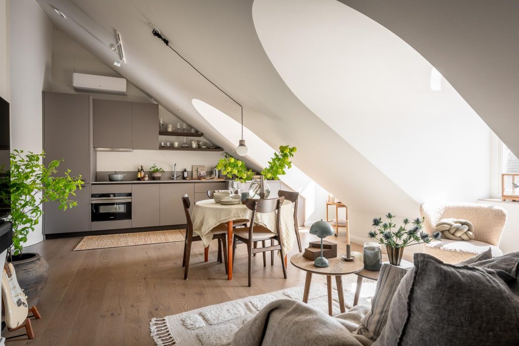 De hanglamp aan de schuine wand is verplaatst, middels een haakjes, zodat precies boven de ronde eettafel hangt.