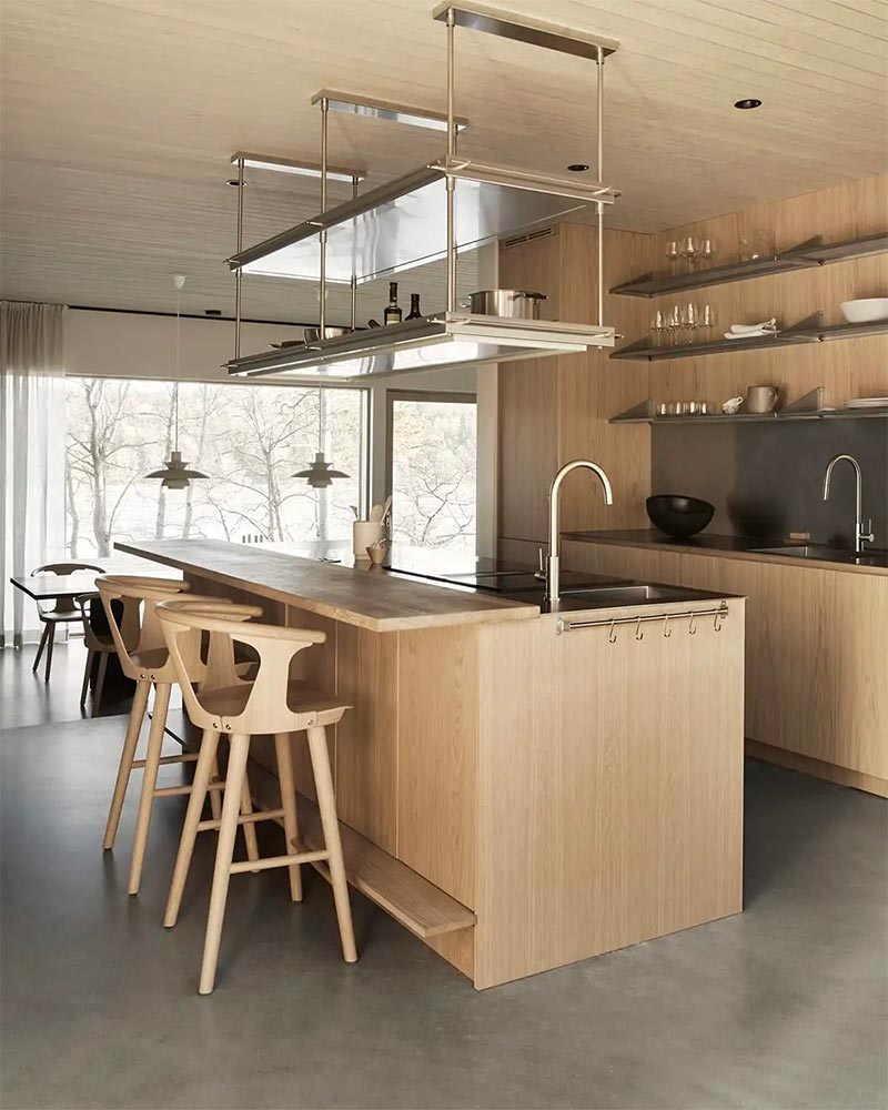 Bij deze mooie houten keuken zijn bijpassende houten barkrukken gekozen, met steun voor zowel je rug, armen en voeten.