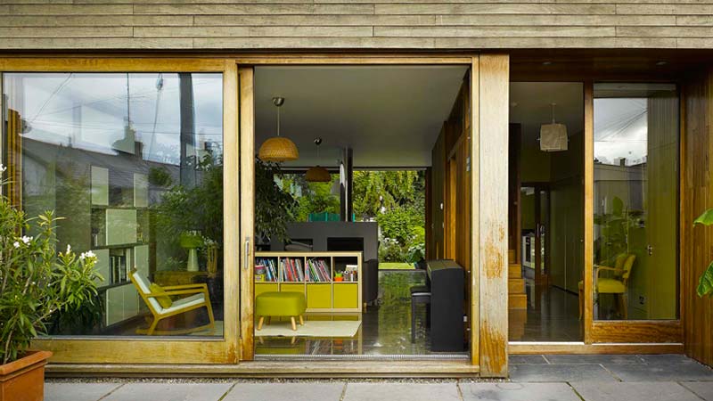 De moderne houten schuifpui verbindt het open huis van Ierse architect John McLaughlin's met zijn tuin.