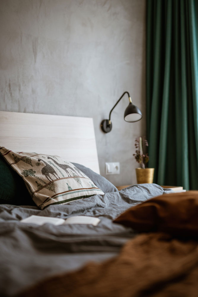In deze slaapkamer scheidt een scheidingswand van houten latten de inloopkast van het bed In deze slaapkamer scheidt een scheidingswand van houten latten de inloopkast van het bed