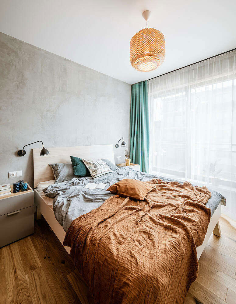 In deze slaapkamer scheidt een scheidingswand van houten latten de inloopkast van het bed
