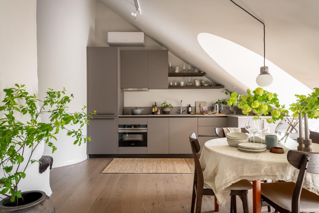 Een moderne kleine compacte keuken met veel kastruimte, onder de schuine wand.