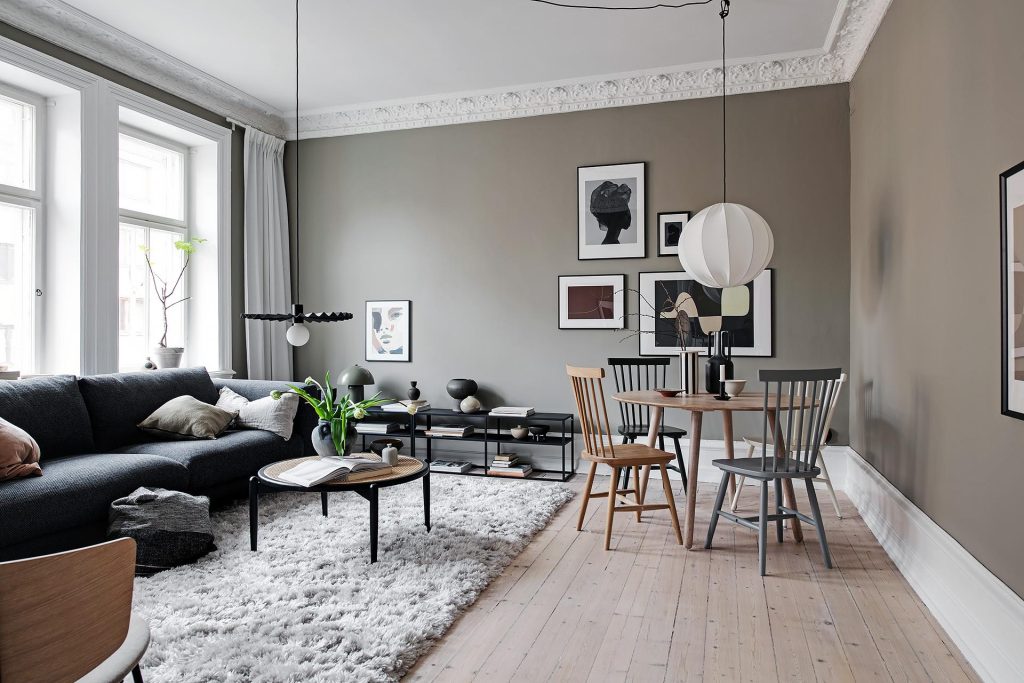 In deze kleine eethoek in een stijlvolle woonkamer is er gekozen voor dezelfde spijlenstoelen in verschillende kleuren.