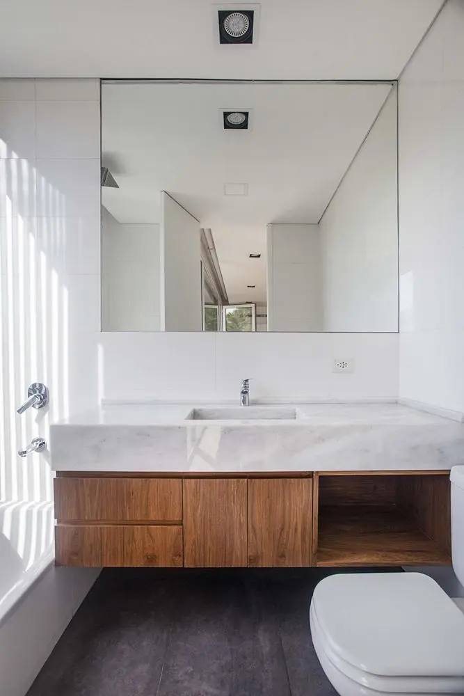 zwevende houten badkamermeubel met marmeren wastafel